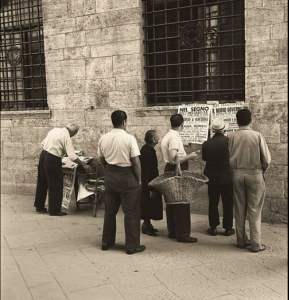 San Gimignano,gruppo di persone che leggono le notizie sulle locandine di un giornale 1955