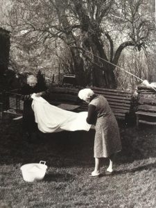 Due belle nonne, ripiegano le lenzuola asciutte dal sole nella campagna pistoiese 