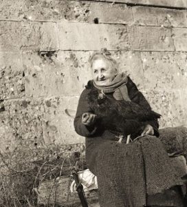 Toscana, luogo imprecisato, anziana mendicante con una gallina legata per una zampa,foto anno 1949