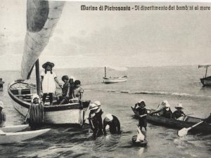 Sono gli anni venti. A Marina di Pietrasanta una colonia di bambini sta giocando in riva al mare.